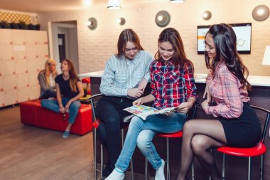 Hostel barda oturmuş, dergi ve konuşma tarama güzel kızlar.