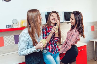 Hostel konuşmak, mutfağında ayakta ve çay içme güzel kızlar.