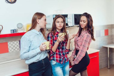 Hostel konuşmak, mutfağında ayakta ve çay içme güzel kızlar.