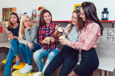 Hostel konuşmak, mutfağında ayakta ve çay içme güzel kızlar.