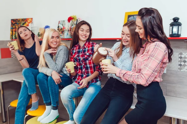 Schöne Mädchen stehen in der Küche des Hostels und reden und trinken Tee. — Stockfoto