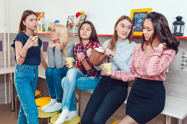 Красиві дівчата стоять на кухні в гуртожитку розмовляють і п'ють чай . — стокове фото