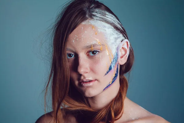 Mode ung kvinna med kreativa ansikte konst på grå bakgrund. — Stockfoto