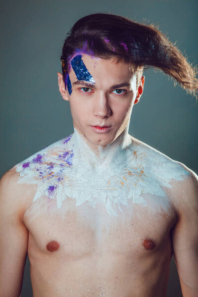 Fashion young man and woman with creative face art on grey background.