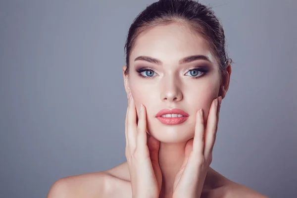 Schöne brünette Mädchen mit Make-up auf grauem Hintergrund, Jugend und Hautpflege-Konzept. — Stockfoto