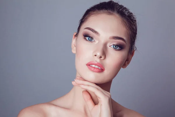 Güzel esmer kız makyaj gri arka plan üzerinde ile gençlik ve cilt bakım kavramı.