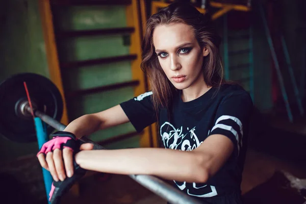Hermosa chica deportiva con maquillaje descansando en el entrenamiento en el gimnasio de estilo antiguo . — Foto de Stock