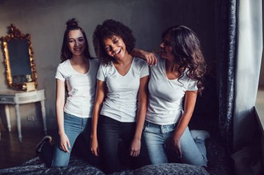 Eğlenceli yatağın üstüne beyaz gömlek içinde güzel gülümseyen kız orgazm. t-shirt modeli.