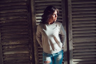 Güzel genç womanl ahşap duvar arka plan üzerinde duran boş Kazak giymiş. Mock-up.