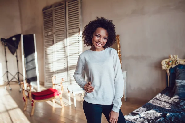 Prachtige Afrikaanse meisje gekleed in lege sweatshirt staan in de oude stijlkamer. Mock-up. — Stockfoto