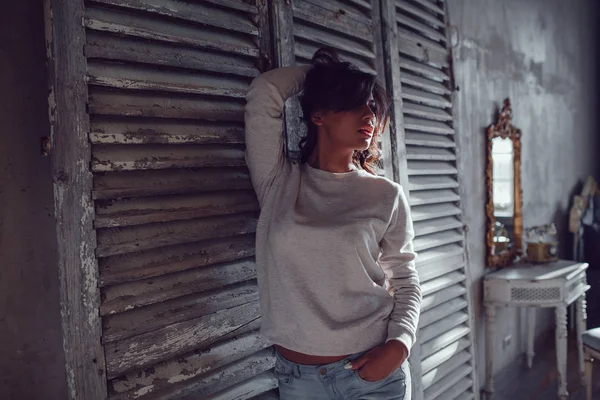 Güzel genç womanl ahşap duvar arka plan üzerinde duran boş Kazak giymiş. Mock-up.