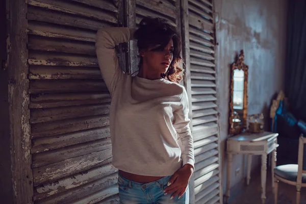 Güzel genç womanl ahşap duvar arka plan üzerinde duran boş Kazak giymiş. Mock-up.