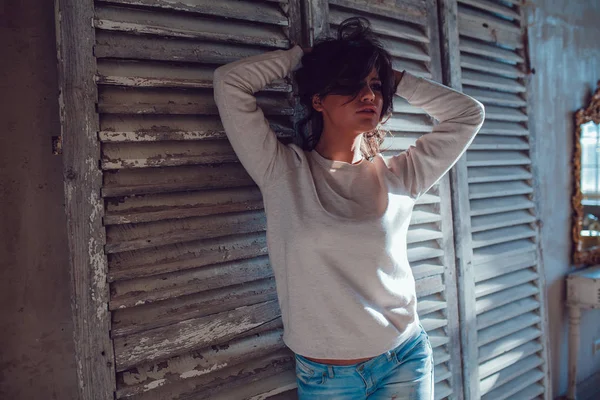 Güzel genç womanl ahşap duvar arka plan üzerinde duran boş Kazak giymiş. Mock-up.