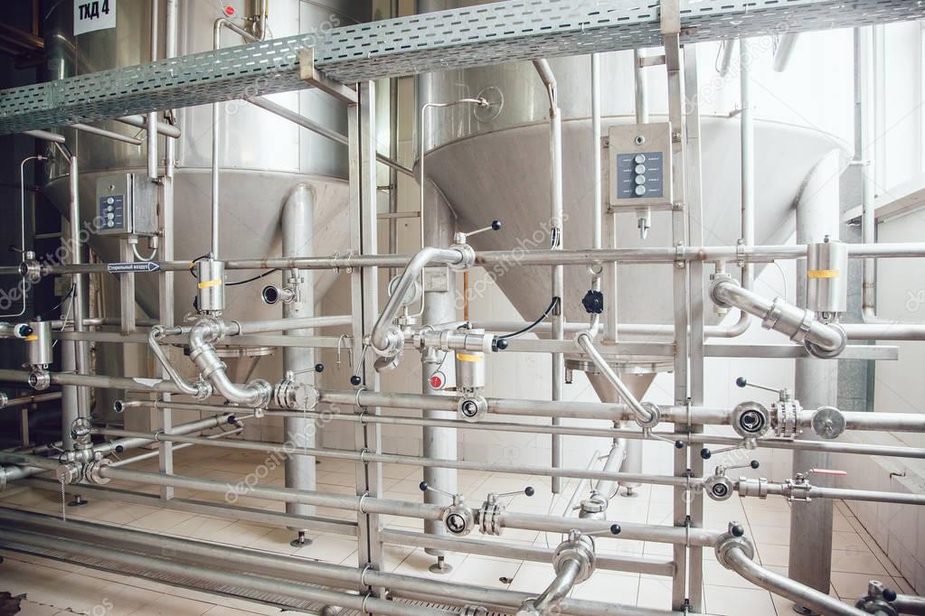 Modern beer plant, with brewing kettles, vessels, tubs and pipes made of stainless steel. Brewery.