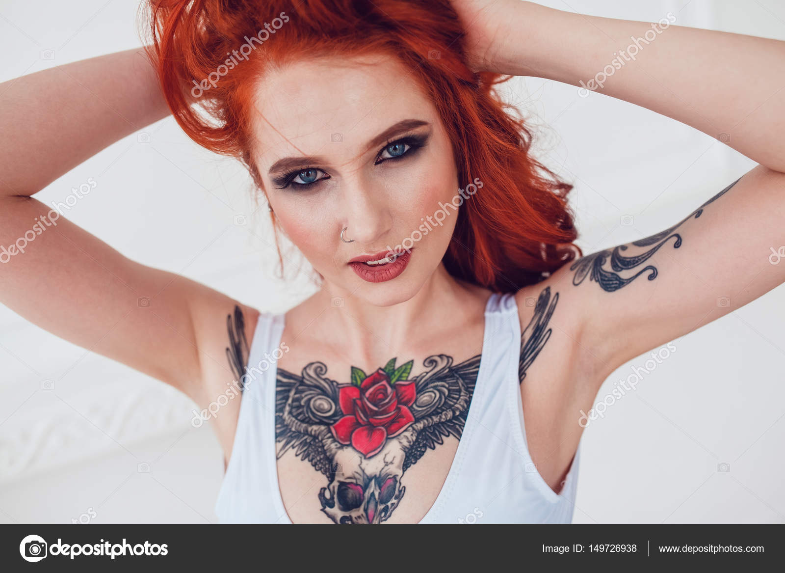 Portrait of a beautiful sexy girl with red hair and a tattoo. Woman with  make-up and curls. Stock Photo by ©airkost 149726938