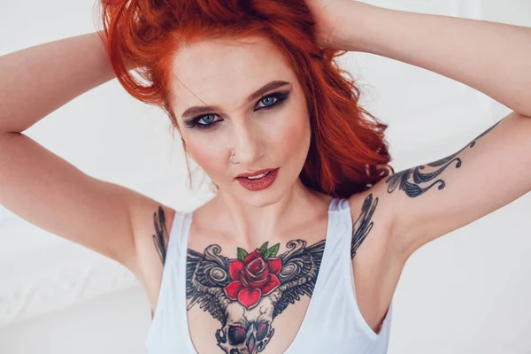 Portrait d'une belle fille sexy aux cheveux roux et un tatouage. Femme avec maquillage et boucles . — Photo