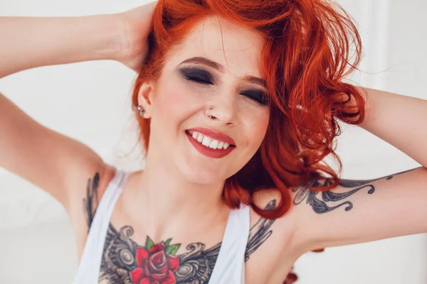 Portrait d'une belle fille sexy aux cheveux roux et un tatouage. Femme avec maquillage et boucles . — Photo