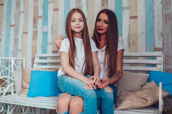 Mamma och dotter med vackra långa hår och bär samma kläder — Stockfoto