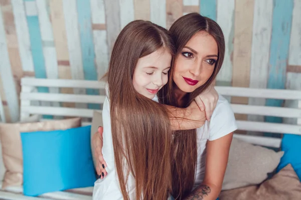 ママと娘は美しい長い髪は抱擁で座っています。. — ストック写真