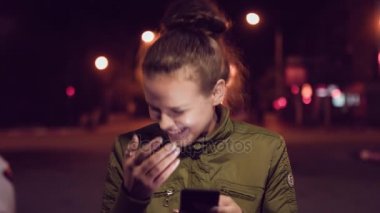Nigth adlı şehirde yürürken akıllı telefon kullanan kadınlar. Kentsel insanların yaşam tarzı arka plan.