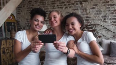 Beyaz T-shirt yapar selfie güzel ve komik kız. İki afro-Amerikalı ve bir Avrupa kızlar.