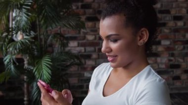 Çekici gülümseyen Afrikalı-Amerikalı kadın olun smartphone kullanarak.