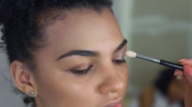 Profesyonel makyöz makyaj Afro-Amerikan modeli yapar. Güzellik ve moda kavramı.