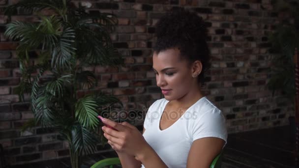 Belle femme afro-américaine souriante avec maquillage à l'aide d'un smartphone . — Video