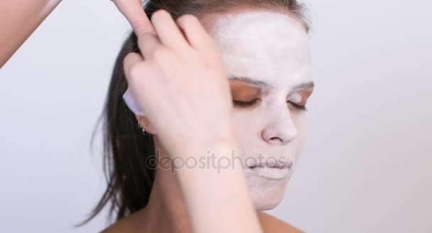 Make-up artist κάνει το κορίτσι Απόκριες κάνουν σε άσπρο φόντο. Απόκριες αντιμετωπίζουν την τέχνη. — Αρχείο Βίντεο