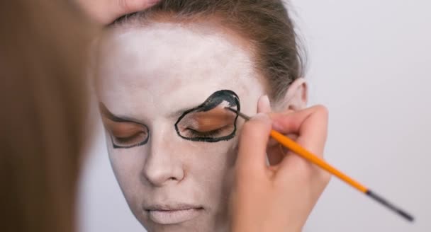 Visagist make-up het meisje halloween maken op een witte achtergrond. Halloween gezicht kunst. — Stockvideo