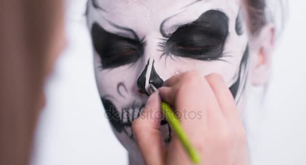 Maquillaje artista hacer que la chica de Halloween maquillaje sobre fondo blanco. Halloween cara arte . — Vídeos de Stock