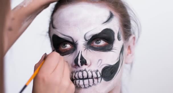 Maquillaje artista hacer que la chica de Halloween maquillaje sobre fondo blanco. Halloween cara arte . — Vídeos de Stock