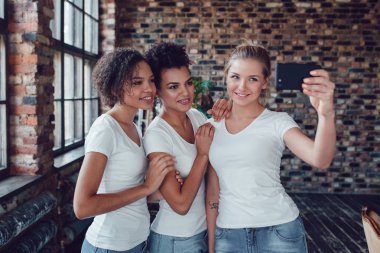 Beyaz T-shirt üç çekici kız selfie pencerenin olun..