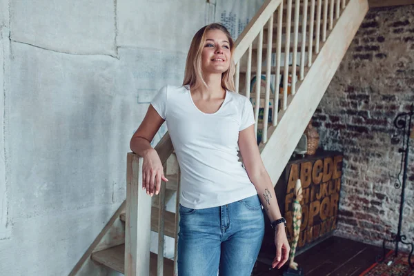 Attraktive blonde Frau steht am Haus in der Nähe der Treppe. — Stockfoto