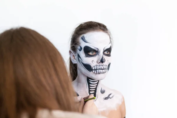 Sminkes, hogy a lány halloween teszik a fehér háttér. Halloween arc art. — Stock Fotó