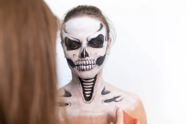 Make-up artist gör flickan halloween gör på vit bakgrund. Halloween ansikte konst. — Stockfoto