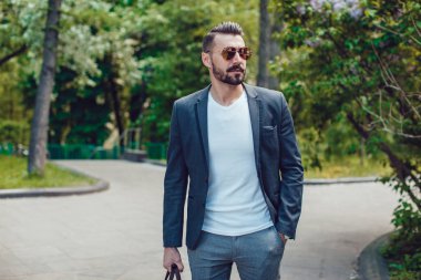Şık adam sakallı ve parkta duran güneş gözlüğü.