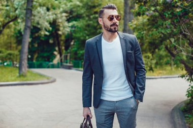 Şık adam sakallı ve parkta duran güneş gözlüğü.