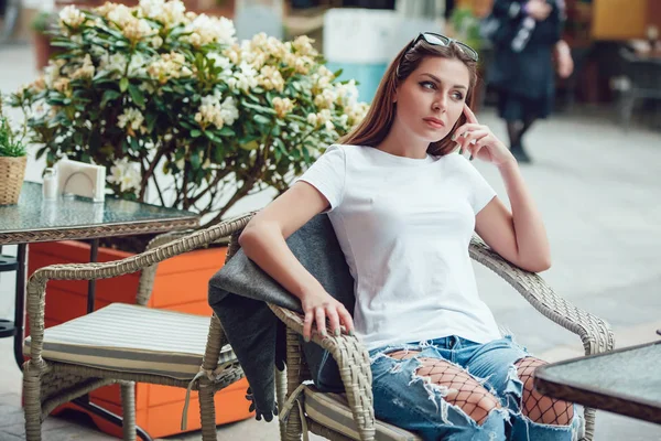 Attractive girl siting in a street cafe at a table. Mock-up. — Stock Photo, Image