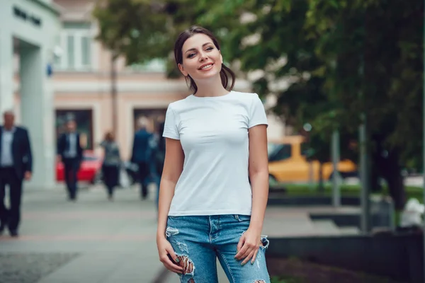 Attractive girl in a white T-shirt on the street. Mock-up. — Stock Photo, Image