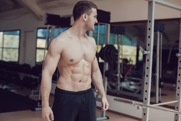 Hombre musculoso sexy en el gimnasio haciendo ejercicio. Torso desnudo macho fuerte . —  Fotos de Stock