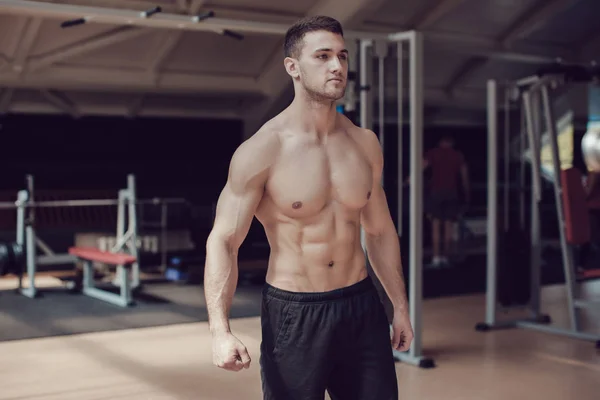 Hombre musculoso sexy en el gimnasio haciendo ejercicio. Torso desnudo macho fuerte . —  Fotos de Stock
