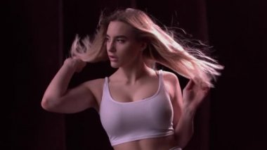 Koyu arka plan üzerinde kamera poz seksi sarışın kadın portresi.