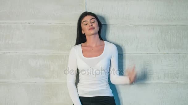 Ελκυστική σέξι κορίτσι σε λευκό T-shirt που θέτουν μπροστά από κάμερα. — Αρχείο Βίντεο