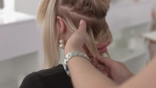 Coiffeur fait une boucles pour une fille, en utilisant la coiffure. Coiffeur au travail . — Video