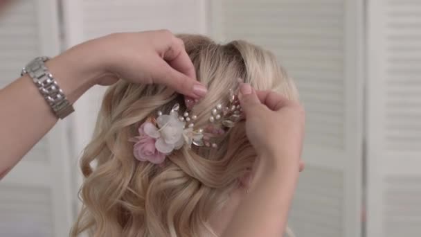 Hair stylist makes a curls for a girl, using hair styling. Hairdresser at work. — Stock Video