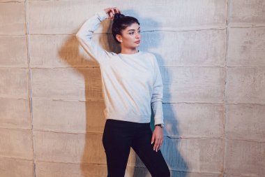 Hafif bir arka plan üzerinde gri bir kazak çekici esmer. Mock-up.