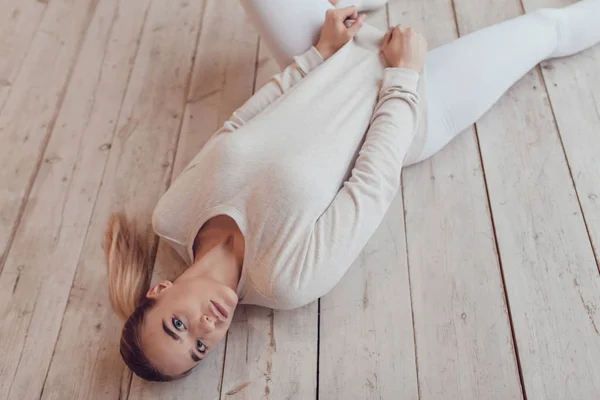 Сексуальна блондинка в сірому светрі лежить на дерев'яній підлозі. Макетні . — стокове фото