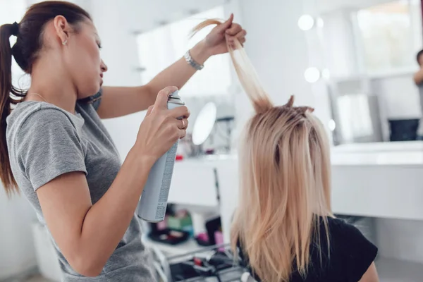 Peluquero-estilista hace el peinado a la chica, el uso de peinado. Corrugado en el cabello . — Foto de Stock