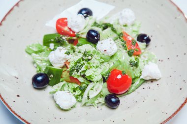 Taze sebzeli Yunan salatası, peynir ve siyah zeytin.